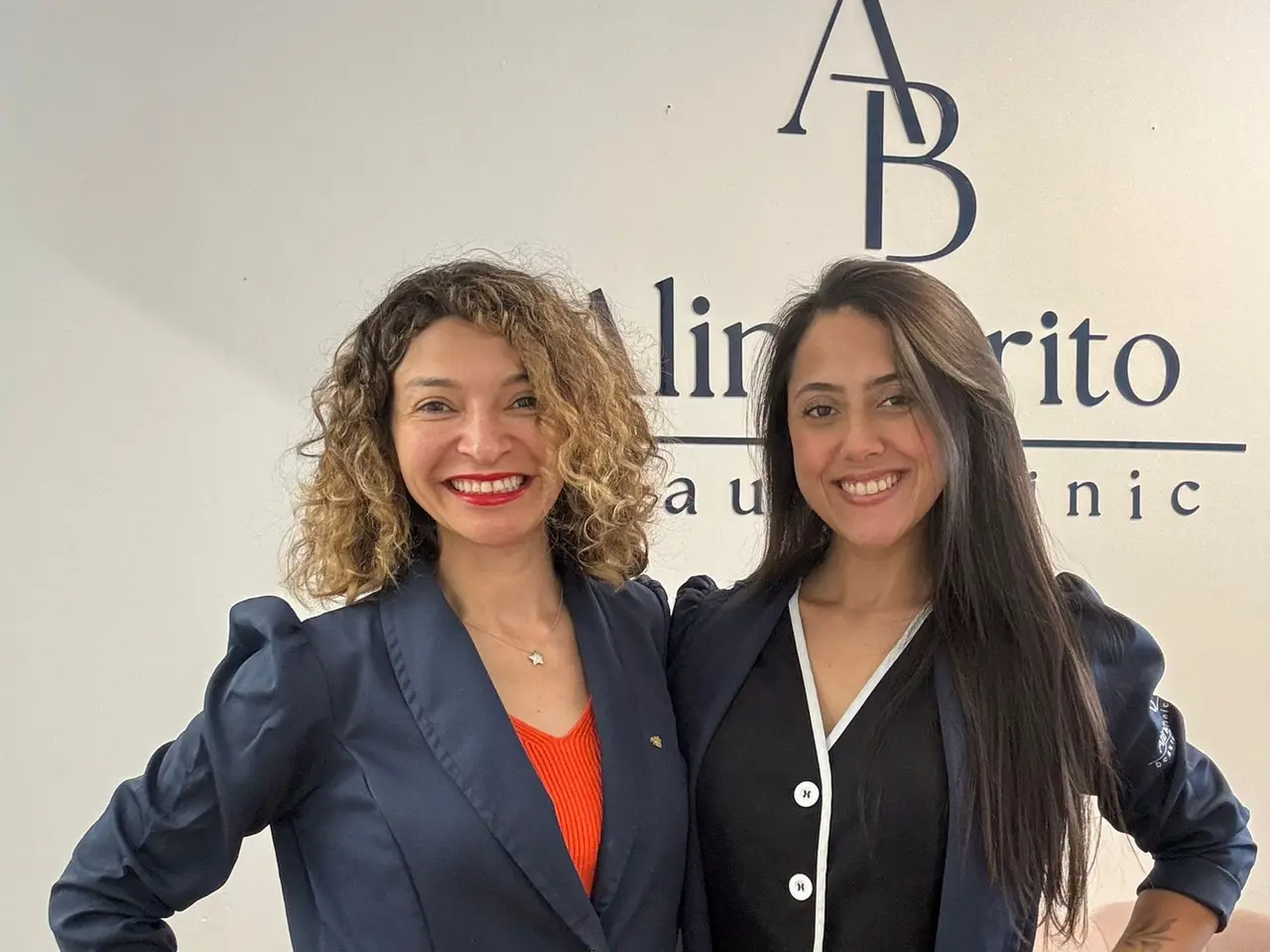 Aline Brito and Talessa in front of the clinic logo