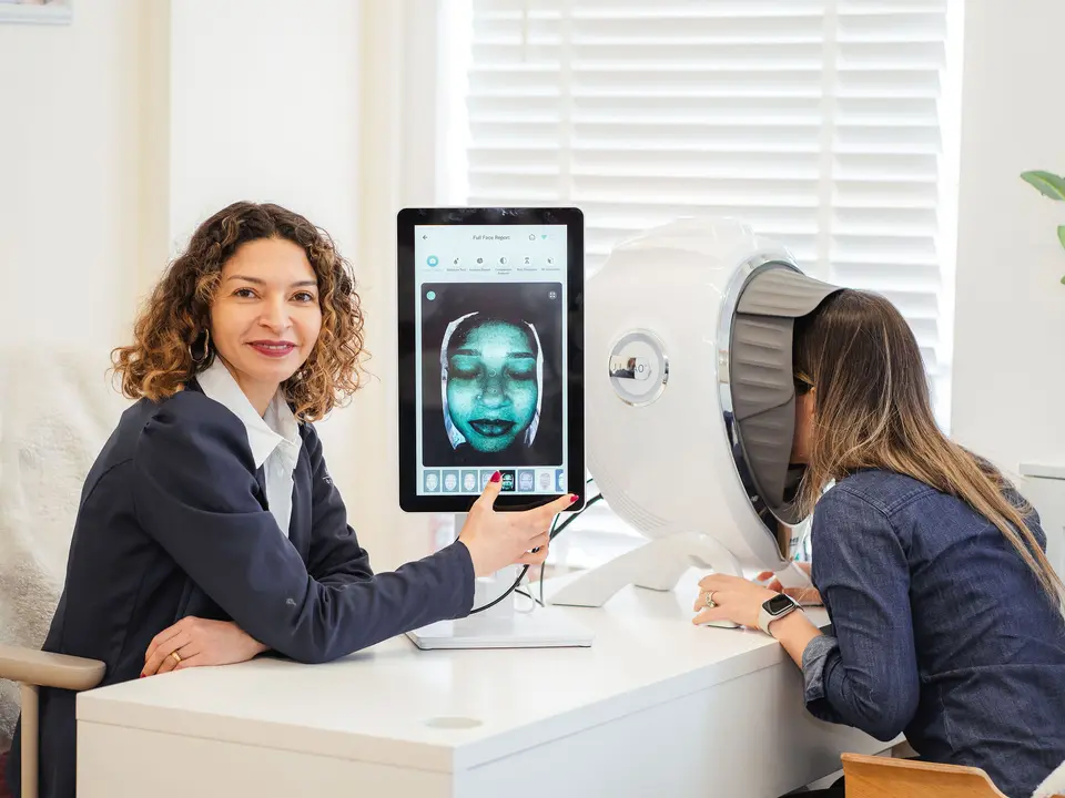 Aline Brito running a digital skin analysis with a client